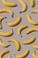 Creative pattern made with yellow bananas on a gray background. Minimal aesthetic concept.