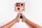 Creative photo of box with cakes between female feets on white background.