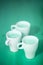 Creative photo of three cups of coffee or cocoa, green turquoise background