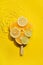 Creative popsicle made from citrus fruit slices in yellow water background with concentric circles and ripples