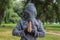Creative religion incognito concept of praying person with face hide under hood and in inside out hoody in outdoor park unfocused