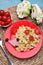 Creative serving for kids. Plate with cute hedgehog made of delicious pasta, sausages and tomatoes on light blue wooden table,