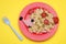 Creative serving for kids. Plate with cute hedgehog made of delicious pasta, sausages and tomatoes on yellow table, flat lay