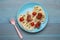 Creative serving for kids. Plate with cute octopuses made of sausages, pasta and vegetables on light blue wooden table, flat lay