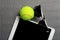 Creative Set Tennis ball, tablet computer and black sunglasses, close-up, on metal background.