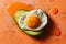 A creative shot of a fried egg on a slice of avocado, creating a vibrant contrast