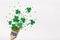 Creative St. Patricks Day concept made with paint brush and green glitter shamrocks and confetti. Minimal flat lay