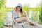 Creative teenager writes in notebook, girl sitting on wooden pier near lake