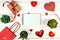 Creative Valentine Day romantic composition with red hearts, satin ribbon, lollipop, gift box and paper bag on white background.