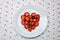 Creative Valentine Day romantic concept composition flat lay top view with heart strawberries on a white plate isolated on a heart