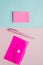 Creative vertical flat lay, top view, office space stationery on pink and blue background