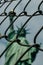 Creative vertical shot of the Statue of Liberty through a gate located in New York, US