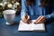 Creative workspace Woman writes in a notebook on a blue table