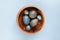 Creatively painted chicken and quail Easter eggs with natural hibiscus dye, look like sea stones in bowl on a gray background.