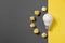 Creativity inspiration, great business idea concept with white light bulb and paper crumpled ball on gray and yellow background.