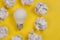 Creativity inspiration, great business idea concept with white light bulb and paper crumpled ball on yellow background.