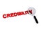 Credibility with magnifying glass on white
