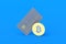 Credit card and coin of bitcoin on blue background