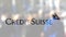 Credit Suisse Group logo on a glass against blurred crowd on the steet. Editorial 3D rendering