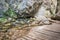 Creek under rocks with wooden footpath