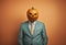 Creepy businessman wearing a carved pumpkin mask.