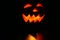 Creepy carved pumpkin face in dark