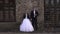 Creepy couple in a wedding dress with makeup for Halloween stand near brick wall