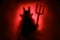 Creepy Devil silhouette on a red background.