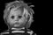 Creepy doll`s head of a young boy on black background