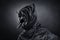 Creepy figure with animal horned skull over dark background