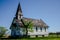 Creepy, old and aged abandoned wooden house in a field under the blue sky