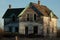 Creepy, old and aged abandoned wooden house in a field under the blue sky