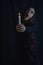 Creepy portrait of a young woman with very long hair who is holding a lit candle and staring backwards with white eyes