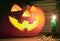 Creepy pumpkin near candle, halloween concept