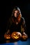 A creepy sorceress in a cloak casts a spell on pumpkins for Halloween