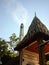 Crematory with smoke from cremate funeral in temple of Thailand. the Crematory  with sun,blue sky and cloud.Crematory in Temple