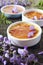 Creme brulee, french traditional dessert, three portions, flowering purple wisteria dressing