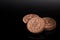 Creme-filled sandwich cookie on dark reflective background