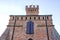 Crenellated brick wall Clock tower with purple window