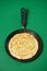 Crepe closeup, thin pancake on a frying pan, green background