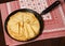 Crepe closeup, thin pancake on a frying pan, wood background