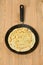 Crepe closeup, thin pancake on a frying pan, wooden background