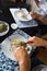 Crepe covered in white sauce lying on plate with broccoli pieces, man eating as seen from above, classy table setting