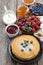 Crepes, fresh berries and jams on wooden table, vertical