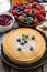 Crepes, fresh berries and jams on wooden table, vertical, top vi