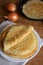 Crepes (Russian Blini) with onions on wooden background, top view. Homemade thin fresh crepes for breakfast