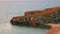 Crescent beach and rocky coast at sunset time