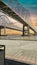 The Crescent City Connection bridge over the Mississippi River with lush green trees and plants and powerful clouds at sunset