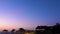 Crescent moon on beautiful night sky over beach with straw umbrellas