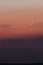 Crescent moon at dusk in a pink gradient colored sky